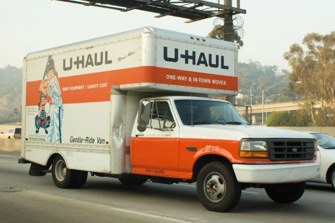 A u-haul truck driving on a highway.